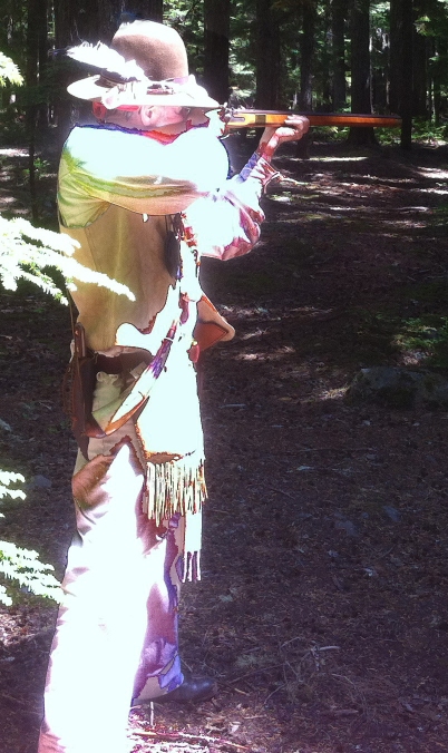 Image of a person in a feathered hat shooting a musket in the woods.